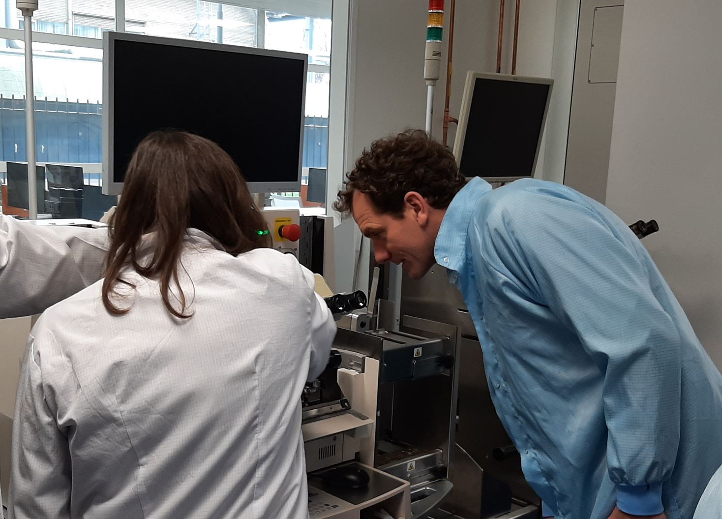 One person in labcoat listening to other person in labcoat